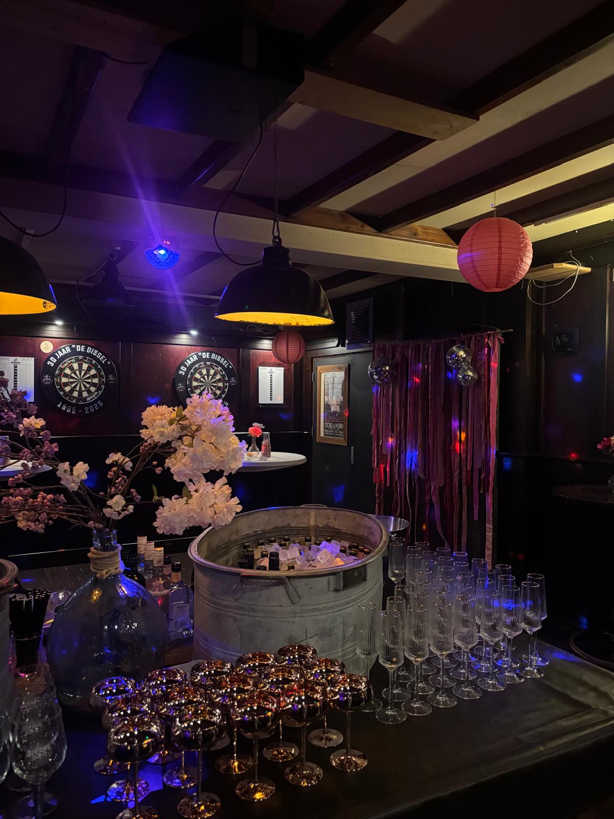 Feestelijk aangeklede achterzaal van Café De Dissel met bloemen, champagneglazen en verlichting